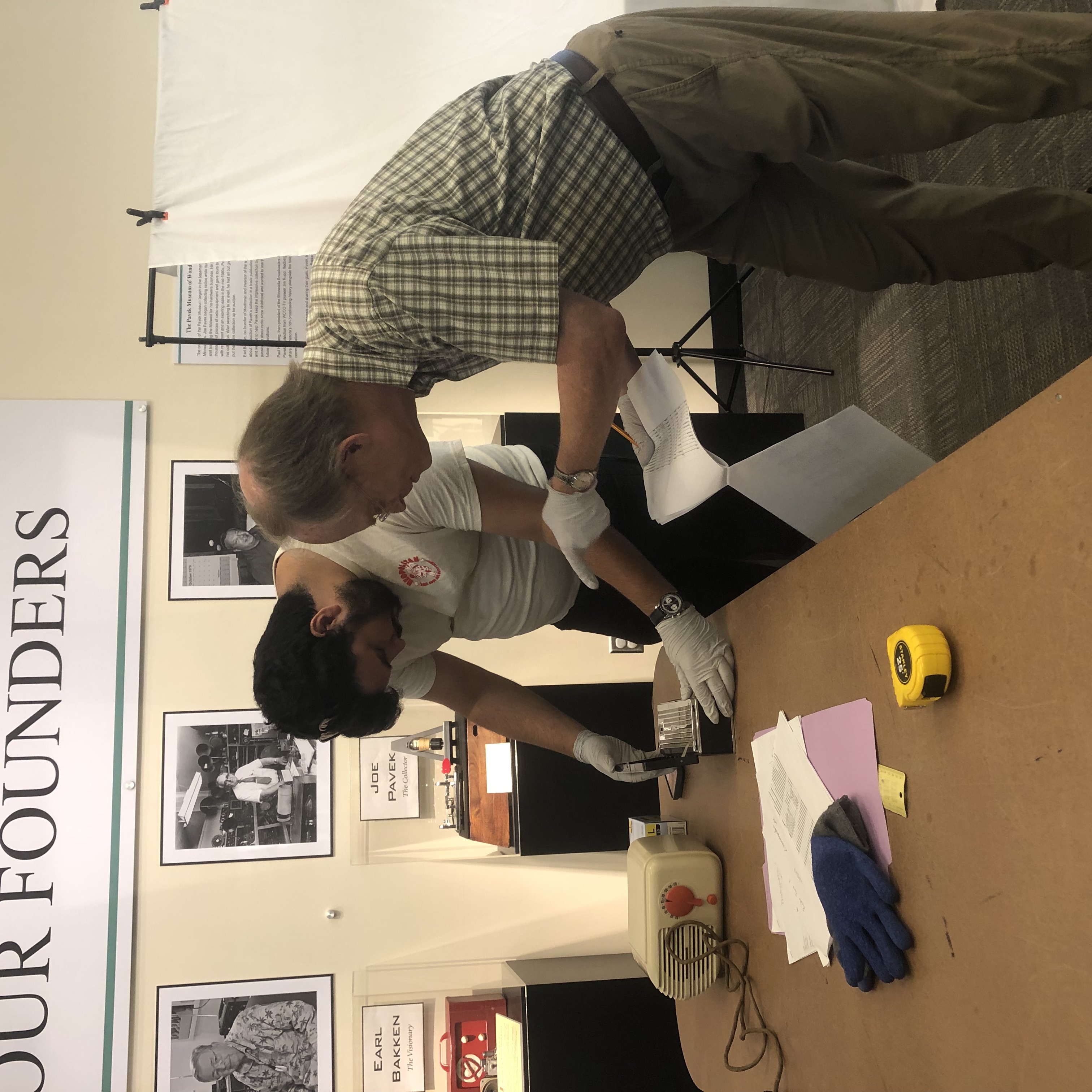 two volunteers looking at artifacts